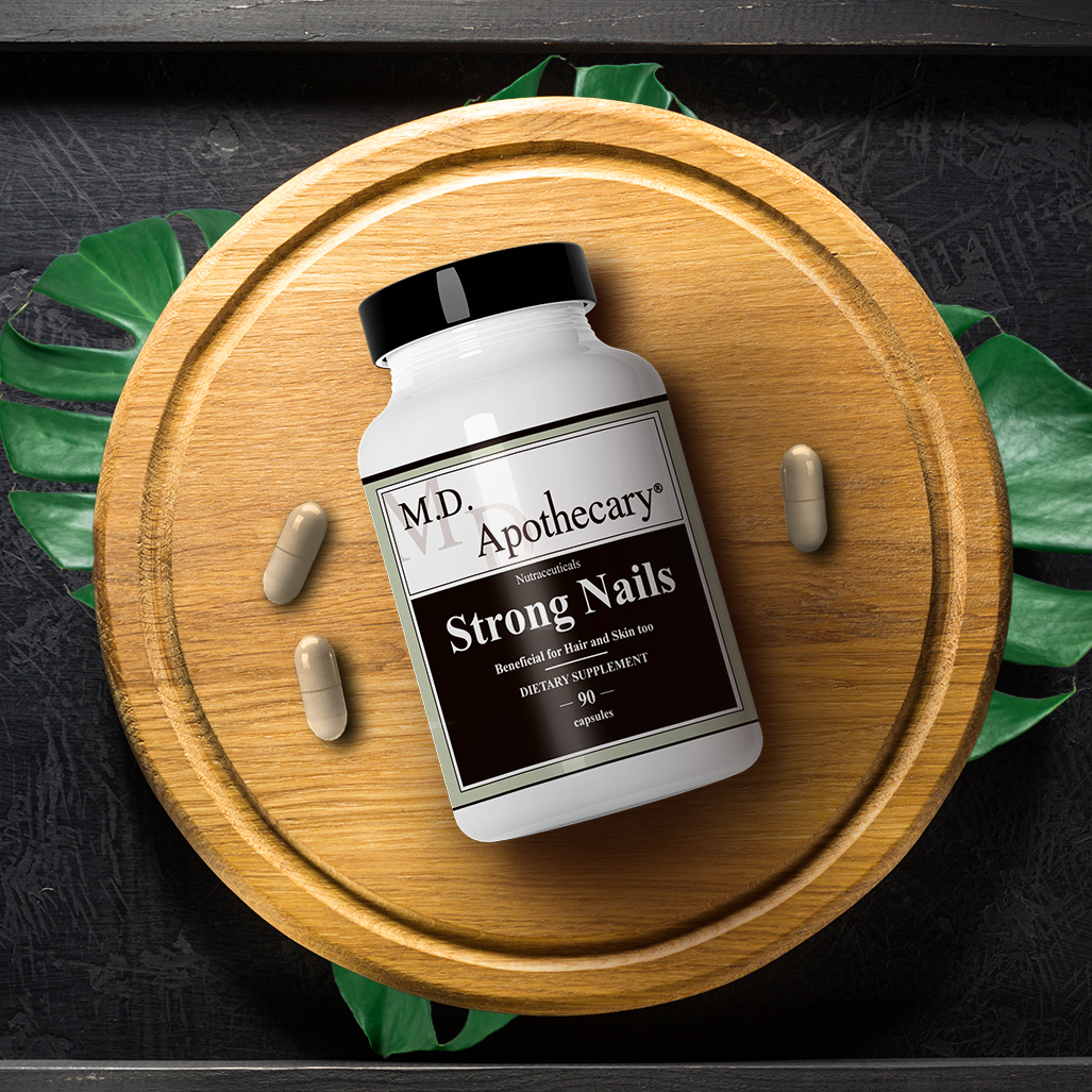 Strong nails supplement laying on a wooden board, used to help strengthen nails, hair and maintain a youthful skin